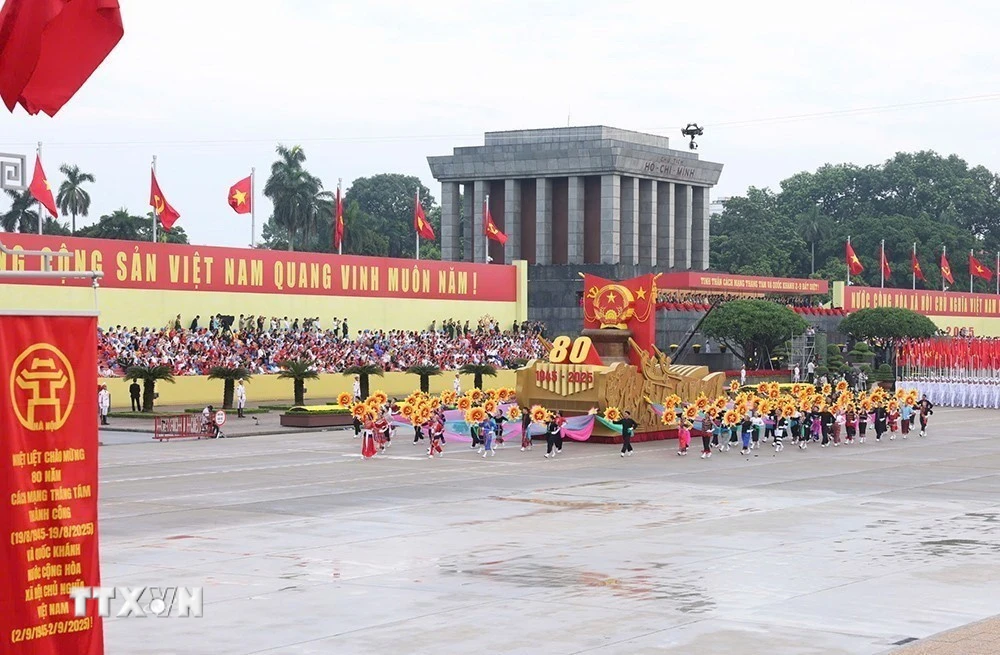 Xe mô hình Quốc huy nước Cộng hòa xã hội chủ nghĩa Việt Nam đi đầu khối diễu binh, diễu hành. (Ảnh: TTXVN)