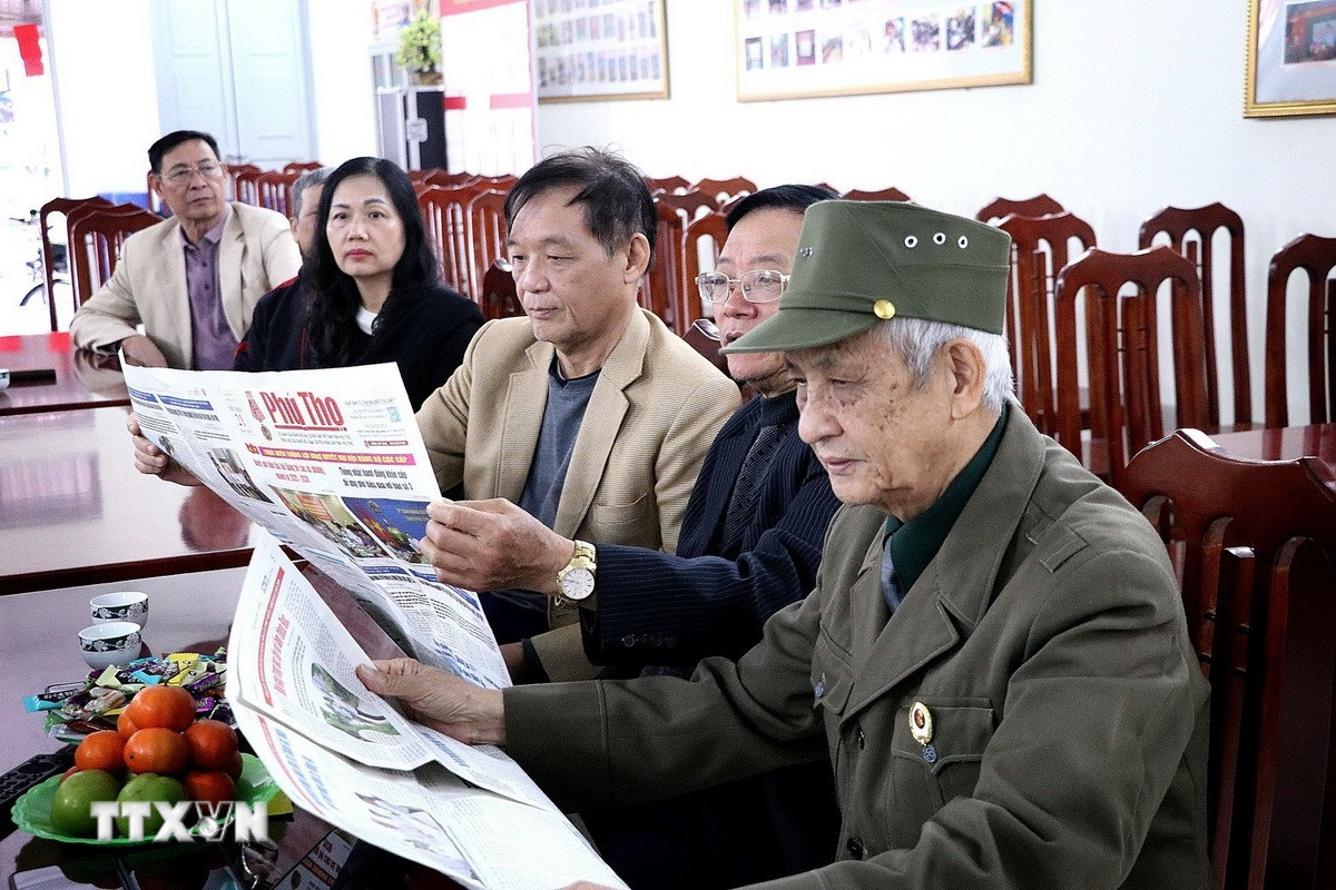 Người dân phường Hòa Bình (Phú Thọ) nghiên cứu thông tin Đại hội đại biểu toàn quốc lần thứ XIV của Đảng qua kênh báo chí. (Ảnh: Thanh Hải/TTXVN)