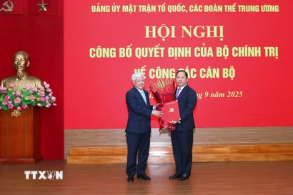 Ông Đỗ Văn Chiến trao quyết định cho ông Nguyễn Phi Long, Ủy viên dự khuyết Trung ương Đảng, Phó Bí thư Đảng ủy Mặt trận Tổ quốc, các đoàn thể Trung ương. (Ảnh: TTXVN phát)