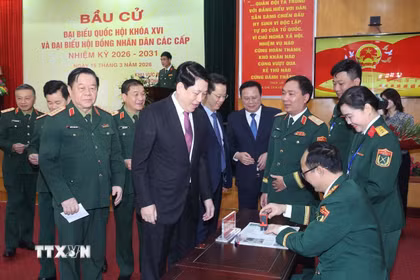 Chủ tịch nước Lương Cường nhận thẻ cử tri đã đóng dấu xác nhận bỏ phiếu tại khu vực bỏ phiếu số 26, phường Hoàn Kiếm, thành phố Hà Nội. (Ảnh: Lâm Khánh/TTXVN)