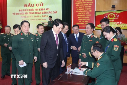 Chủ tịch nước Lương Cường nhận thẻ cử tri đã đóng dấu xác nhận bỏ phiếu tại khu vực bỏ phiếu số 26, phường Hoàn Kiếm, thành phố Hà Nội. (Ảnh: Lâm Khánh/TTXVN)