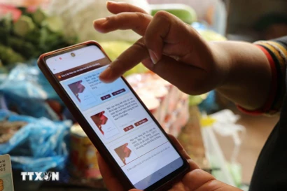 Người dân góp ý Dự thảo các Văn kiện trình Đại hội XIV của Đảng thông qua ứng dụng VNeID. (Ảnh: Nguyên Dung/TTXVN)