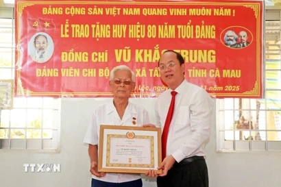 Bí thư Tỉnh ủy Cà Mau Nguyễn Hồ Hải trao Huy hiệu 80 năm tuổi Đảng cho đảng viên Vũ Khắc Trung (sinh năm 1928) tại xã Tân Lộc, tỉnh Cà Mau. (Ảnh: Huỳnh Anh/TTXVN)