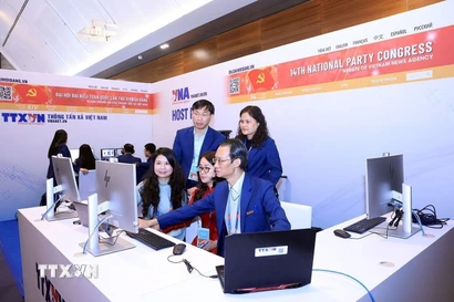 Phóng viên, biên tập viên của TTXVN tác nghiệp tại Trung tâm báo chí của Đại hội. (Ảnh: TTXVN phát)