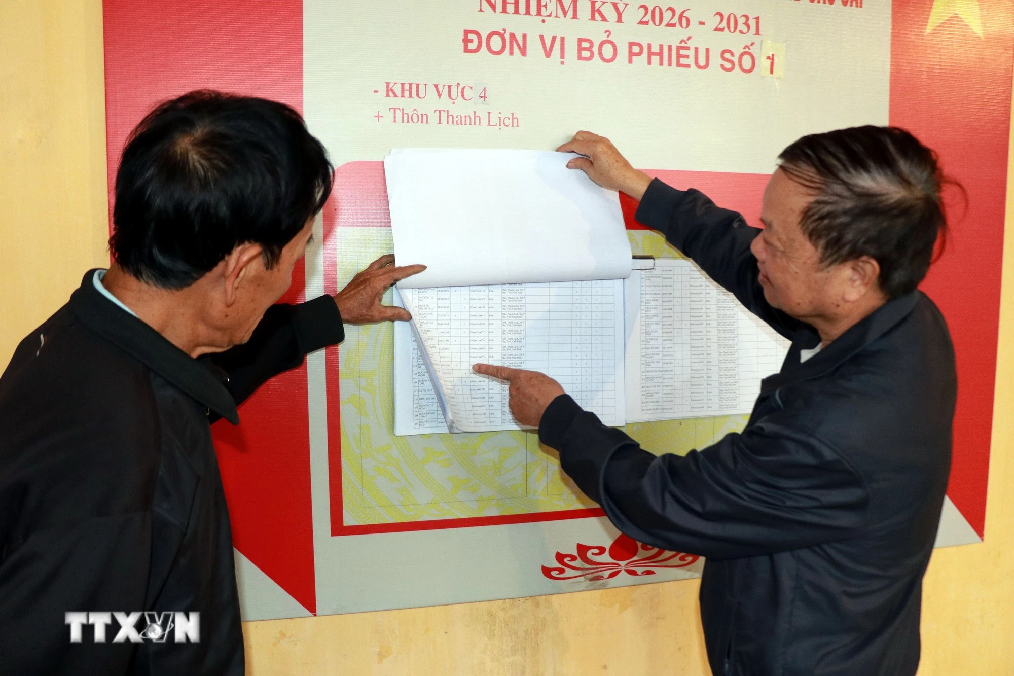 Người dân thôn Thanh Lịch, xã Ý Yên (Ninh Bình) tra cứu danh sách cử tri. (Ảnh: Nguyễn Lành/TTXVN)