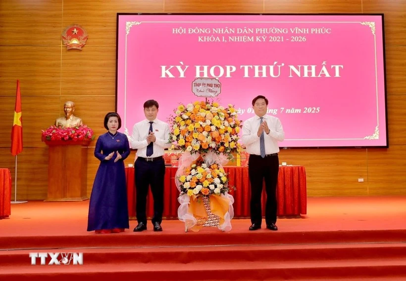 Chủ tịch UBND tỉnh, Phó Bí thư Tỉnh ủy Phú Thọ Trần Duy Đông (phải) tặng hoa chúc mừng lãnh đạo phường Vĩnh Phúc tại kỳ họp. (Ảnh: Hoàng Hùng/TTXVN)