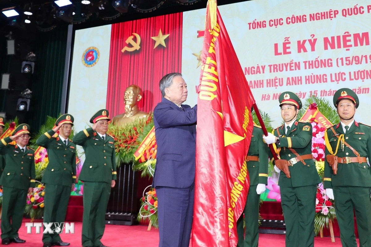 Tổng Bí thư Tô Lâm gắn Danh hiệu Anh hùng Lực lượng Vũ trang Nhân dân lên Quân kỳ Quyết thắng của Tổng cục Công nghiệp Quốc phòng. (Ảnh: Trọng Đức/TTXVN)