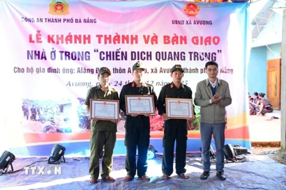 Chủ tịch Ủy ban Nhân dân xã A Vương Briu Quân tặng Giấy khen cho lực lượng tham gia “Chiến dịch Quang Trung” xây, sửa nhà ở cho đồng bào bị thiệt hại do thiên tai vào cuối tháng 10 và đầu tháng 11/2025. (Ảnh: TTXVN phát)