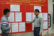 Đảng viên Chi bộ thôn Nam Quan, xã biên giới Đồng Đăng, tỉnh Lạng Sơn tuyên truyền hướng dẫn bầu cử tại nơi niêm yết danh sách những người ứng cử. (Ảnh: Quang Duy/TTXVN)