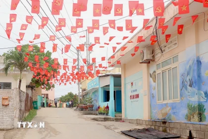 Những con hẻm nhỏ trên xã đảo Nhơn Châu được trang hoàng cờ hoa rực rỡ. (Ảnh: Quang Thái/TTXVN)