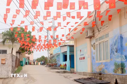 Những con hẻm nhỏ trên xã đảo Nhơn Châu được trang hoàng cờ hoa rực rỡ. (Ảnh: Quang Thái/TTXVN)
