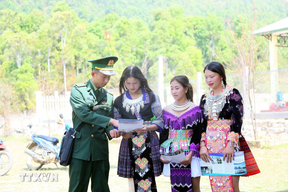 Cán bộ Đồn Biên phòng Mường Lèo (Ban Chỉ huy Bộ đội Biên phòng tỉnh Sơn La) tuyên truyền, vận động đồng bào dân tộc Mông ở bản Sam Quảng đi bầu cử. (Ảnh: Quang Quyết/TTXVN)