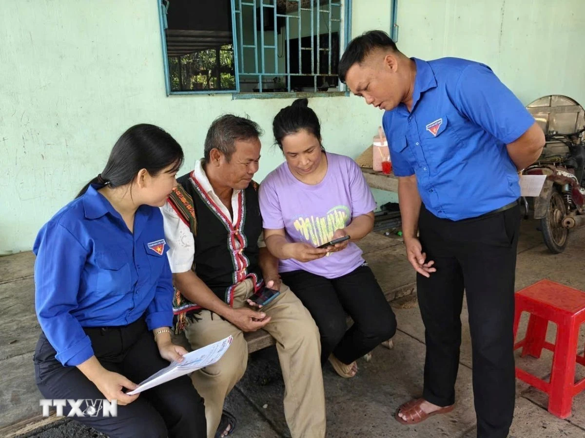 Đoàn thanh niên xã Tân Khai tuyên truyền hướng dẫn truy cập vào điện thoại thông tin bầu cử trong vùng đồng bào thiểu số. (Ảnh: K GỬIH/TTXVN)