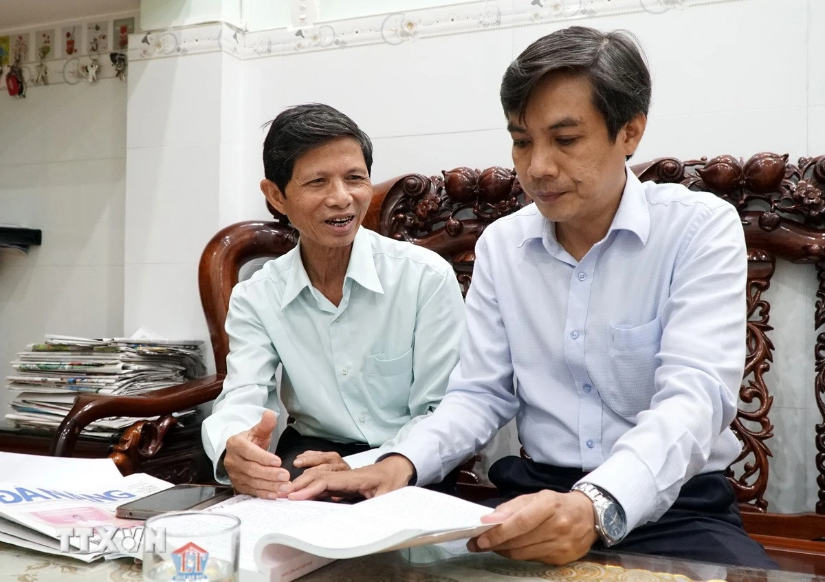 Ông Phạm Công Lương, Bí thư Chi bộ Khu dân cư Bình Phước 1, phường Hải Châu, thành phố Đà Nẵng (bên trái) chia sẻ cảm nhận về dự thảo Văn kiện Đại hội với cán bộ phường Hải Châu. (Ảnh: Quốc Dũng/TTXVN)