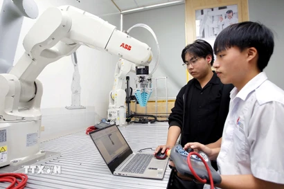Sinh viên thực hành thử nghiệm các thuật toán điều khiển cánh tay robot tại phòng thí nghiệm Robotics, Trường Đại học Công nghiệp Thành phố Hồ Chí Minh. (Ảnh: Thanh Vũ/TTXVN)