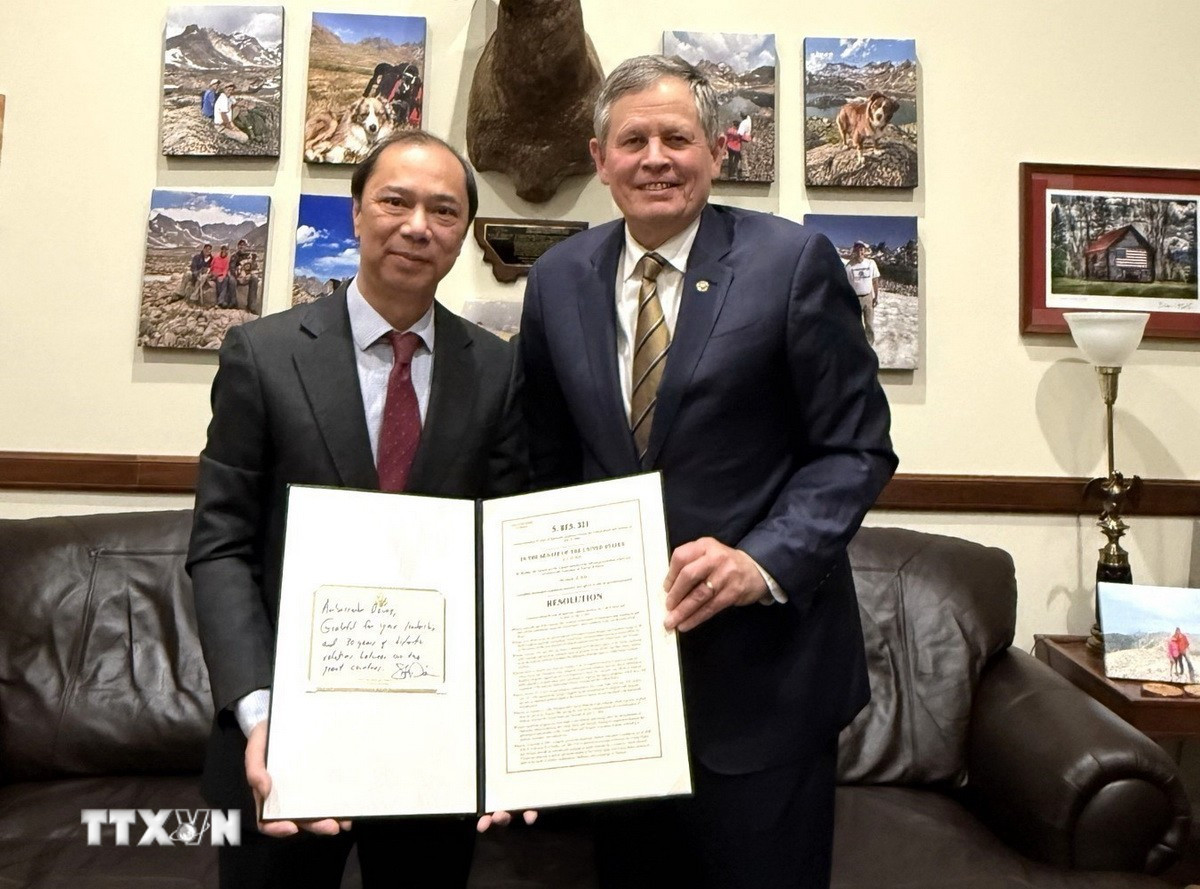 Thượng nghị sỹ Mỹ Steve Daines trao Nghị quyết của Thượng viện Mỹ kỷ niệm 30 năm bình thường hóa quan hệ ngoại giao Việt Nam-Mỹ cho Đại sứ Việt Nam tại Mỹ Nguyễn Quốc Dũng. (Ảnh: TTXVN phát)