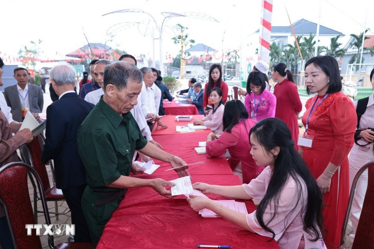 Những cử tri đầu tiên của xã đảo Minh Châu, Hà Nội nhận phiếu bầu cử. (Ảnh: Trần Việt/TTXVN)