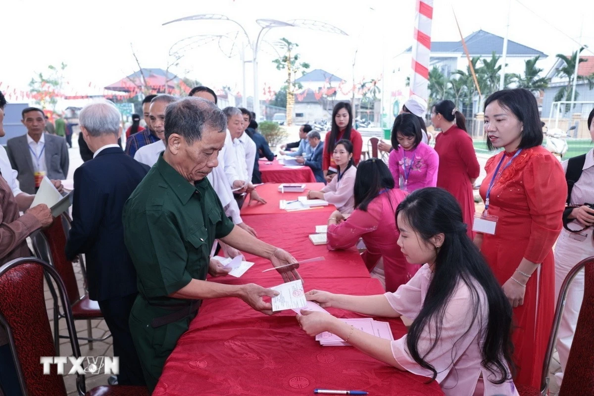 Những cử tri đầu tiên của xã đảo Minh Châu, Hà Nội nhận phiếu bầu cử. (Ảnh: Trần Việt/TTXVN)