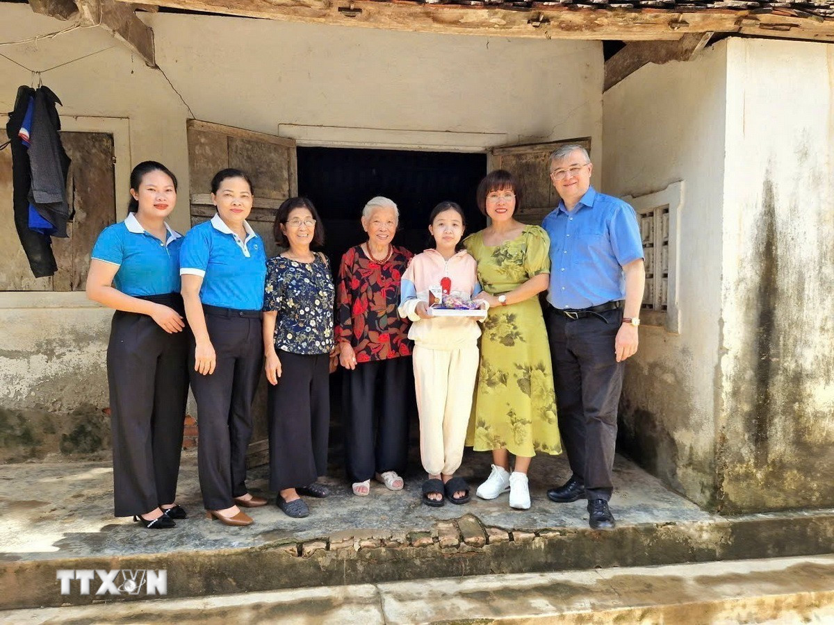 Tiến sỹ Phan Bích Thiện (thứ 2 từ phải sang), Chủ tịch Diễn đàn phụ nữ Việt Nam tại châu Âu, thăm gia đình con đỡ đầu tại Việt Nam. (Ảnh: TTXVN phát)