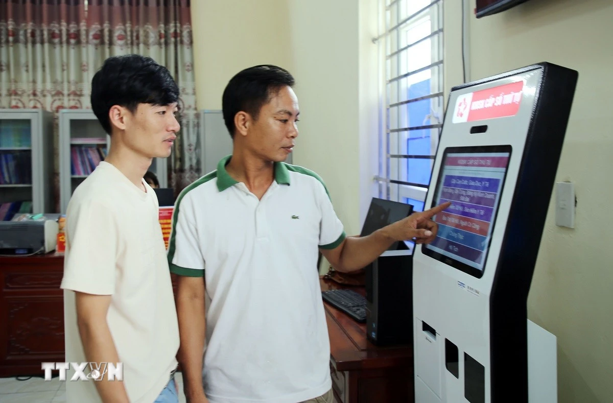 Người dân xã Yên Mô lấy số thứ tự giải quyết thủ tục hành chính. (Ảnh: Nguyễn Lành/TTXVN)