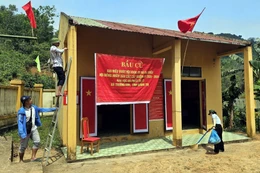 Bà con đồng bào Bru-Vân Kiều (bản Nước Đắng, xã Trường Sơn, Quảng Trị) trang trí khu vực bỏ phiếu, chuẩn bị sẵn sàng cho việc bỏ phiếu sớm vào ngày 8/3. (Ảnh: TTXVN phát)