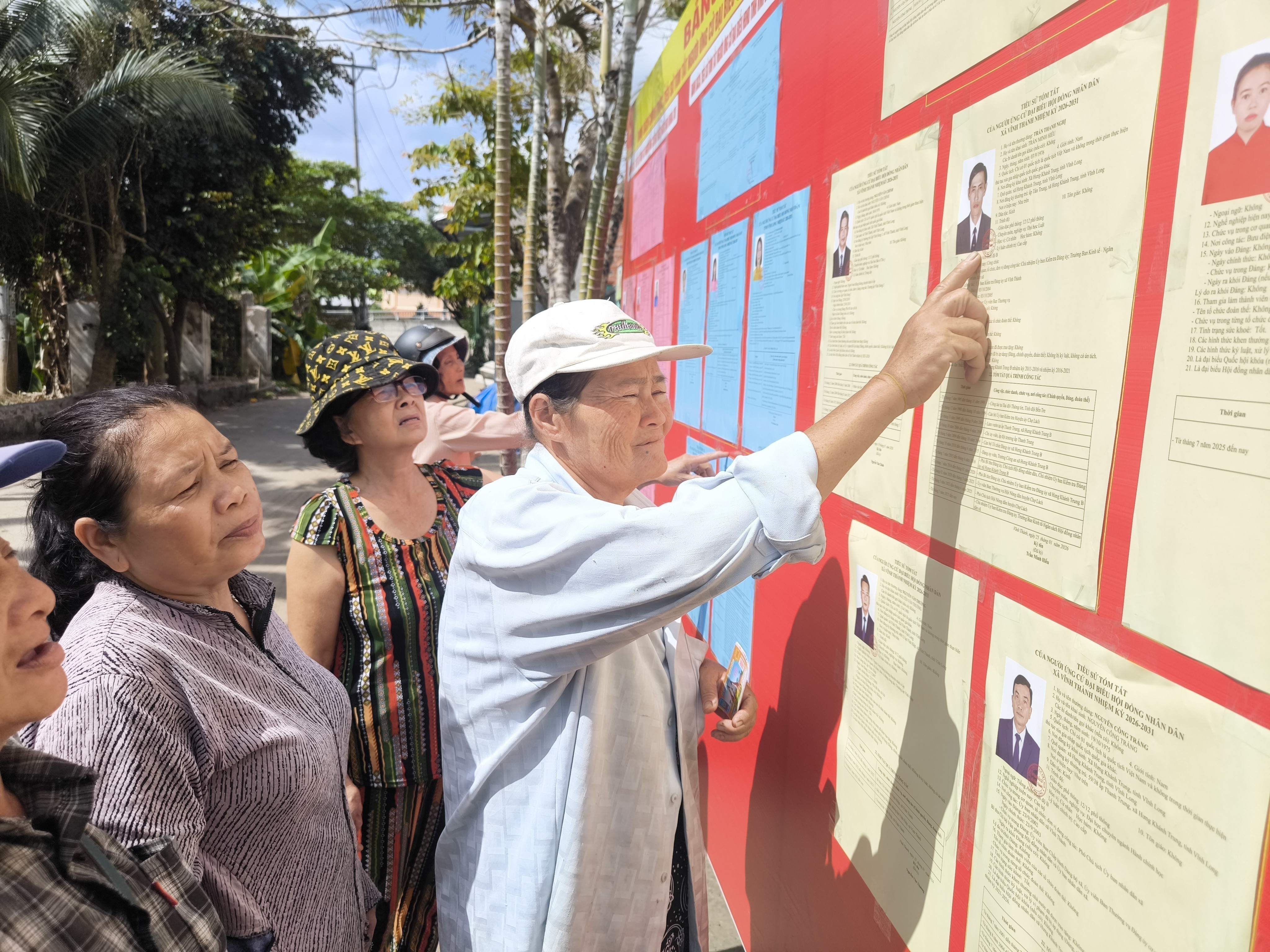 Giáo dân ấp Vĩnh Bắc, xã Vĩnh Thành (Vĩnh Long) tìm hiểu thông tin về các đại biểu ứng cử. (Ảnh: Huỳnh Phúc Hậu/TTXVN)