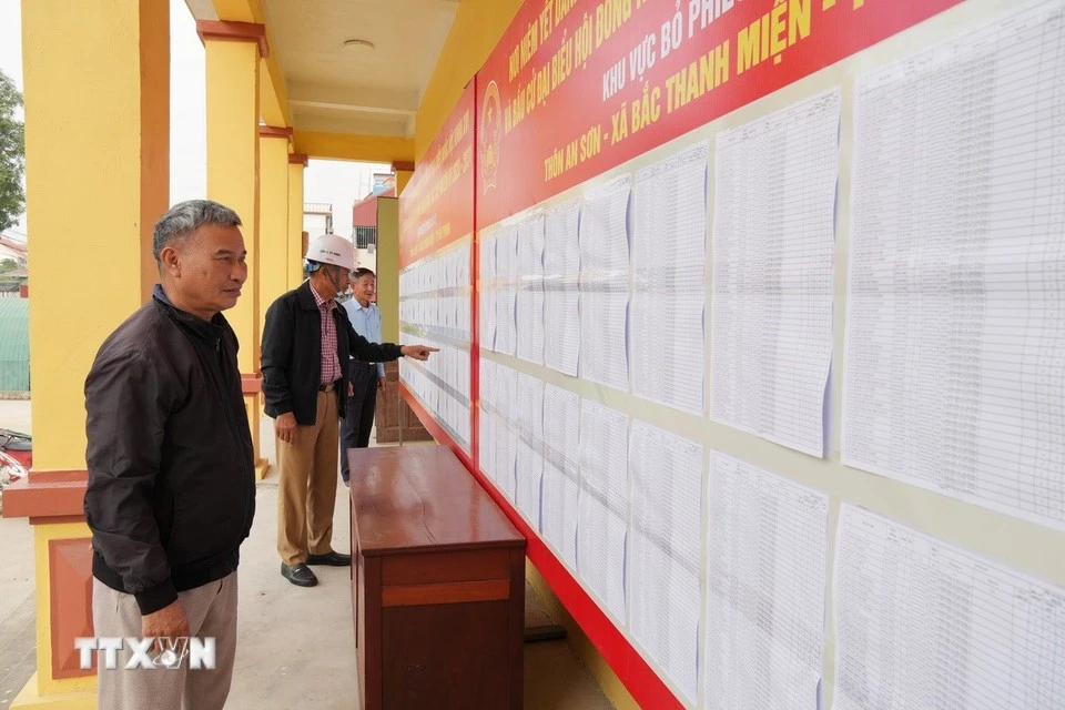Cử tri kiểm tra danh sách niêm yết. (Ảnh: Tiến Vĩnh/TTXVN)
