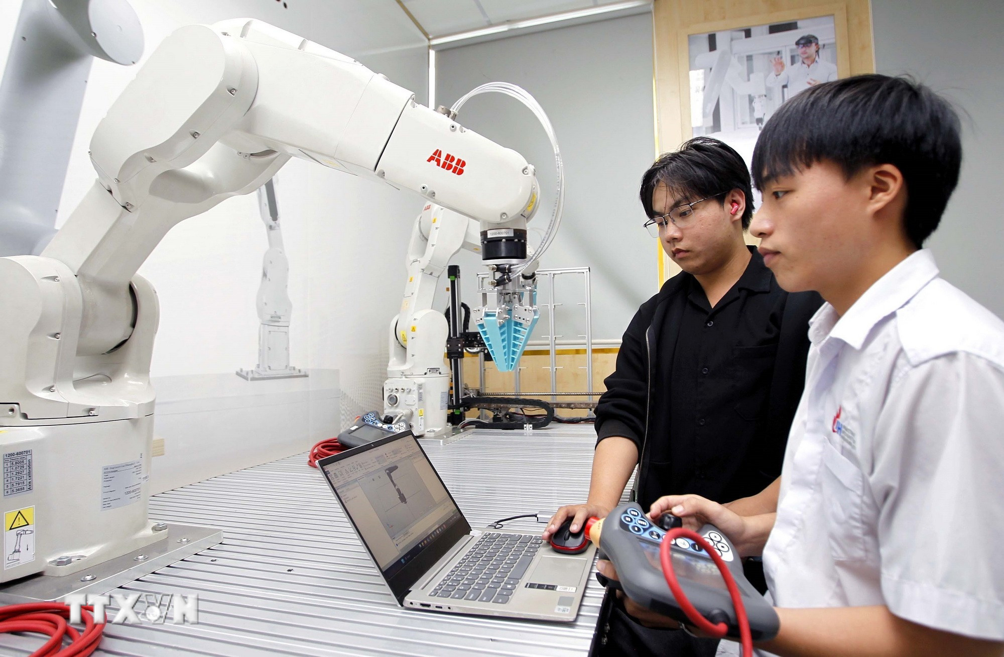 Sinh viên thực hành thử nghiệm các thuật toán điều khiển cánh tay robot tại phòng thí nghiệm Robotics, Trường Đại học Công nghiệp Thành phố Hồ Chí Minh. (Ảnh: Thanh Vũ/TTXVN)