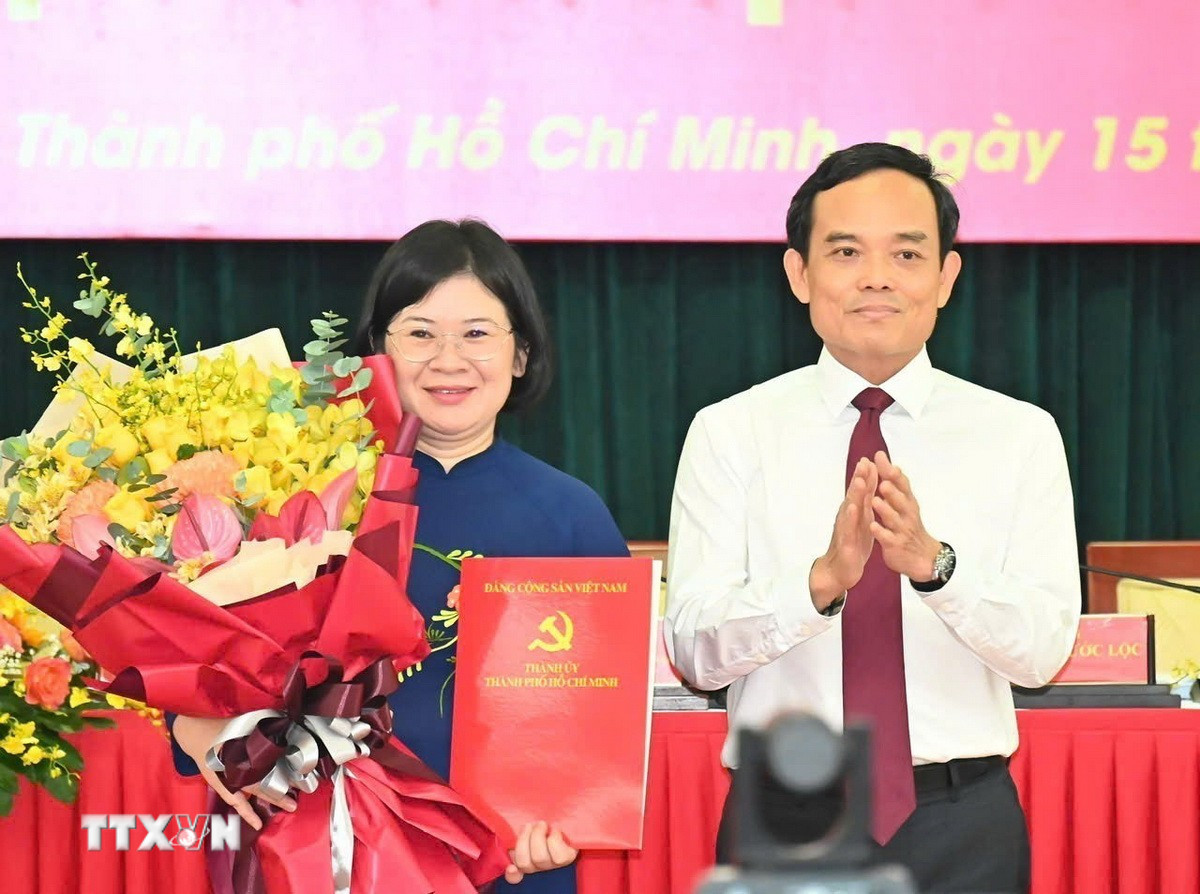 Bí thư Trung ương Đảng, Bí thư Thành ủy Thành phố Hồ Chí Minh Trần Lưu Quang trao quyết định cho đồng chí Văn Thị Bạch Tuyết. (Ảnh: TTXVN phát)