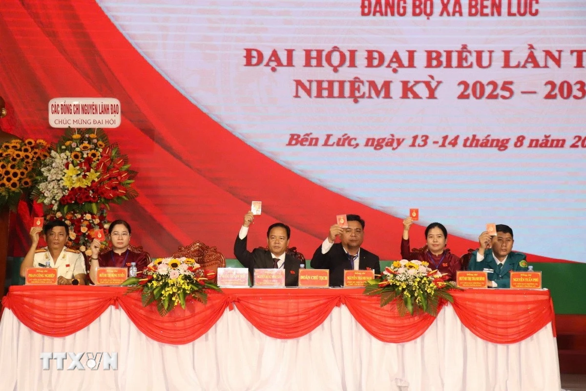 Đoàn Chủ tịch Đại hội Đảng bộ xã Bến Lức biểu quyết thông qua dự thảo Nghị quyết Đại hội. (Ảnh: Thanh Bình/TTXVN)