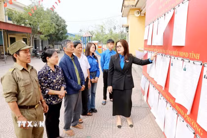 Đoàn Thanh niên phường Hồng Châu (Hưng Yên) thông tin về người ứng cử cho cử tri tại khu vực bỏ phiếu. (Ảnh: Thu Hoài/TTXVN)