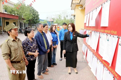 Đoàn Thanh niên phường Hồng Châu (Hưng Yên) thông tin về người ứng cử cho cử tri tại khu vực bỏ phiếu. (Ảnh: Thu Hoài/TTXVN)