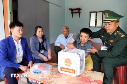 Tổ bầu cử số 2 bản Luốc Làu, xã vùng cao biên giới Mường Mìn mang hòm phiếu lưu động hỗ trợ cho cử tri khuyết tật vận động Vi Văn Lui thực hiện quyền bầu cử.