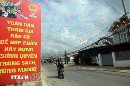 Các tuyến đường về xã Diên Điền, vùng rốn lũ lịch sử 11/2025, được trang hoàng rực rỡ cờ hòa. (Ảnh: Đặng Tuấn/TTXVN)