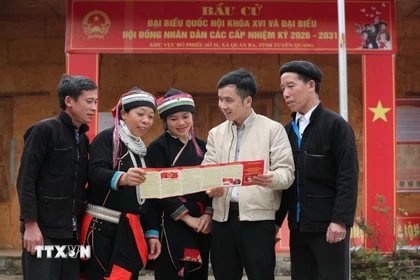 Cán bộ tuyên truyền bầu cử cho các cử tri tại thôn Nặm Đăm, xã Quản Bạ. (Ảnh: Minh Đức/TTXVN)