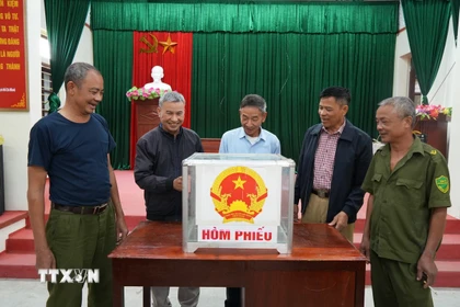 Kiểm tra hòm phiếu tại khu vực bỏ phiếu. (Ảnh: Tiến Vĩnh/TTXVN)