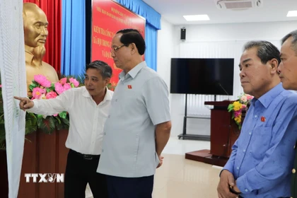 Phó Chủ tịch Quốc hội Trần Quang Phương kiểm tra bản đồ các điểm bầu cử trên địa bàn thành phố. (Ảnh: Hồng Thái/TTXVN)