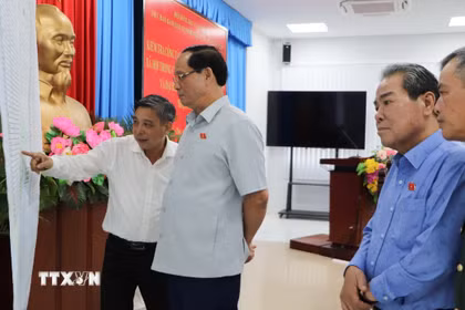 Phó Chủ tịch Quốc hội Trần Quang Phương kiểm tra bản đồ các điểm bầu cử trên địa bàn thành phố. (Ảnh: Hồng Thái/TTXVN)