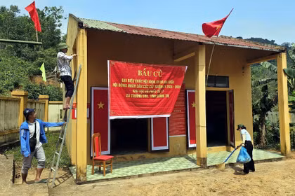 Bà con đồng bào Bru-Vân Kiều (bản Nước Đắng, xã Trường Sơn, Quảng Trị) trang trí khu vực bỏ phiếu, chuẩn bị sẵn sàng cho việc bỏ phiếu sớm vào ngày 8/3. (Ảnh: TTXVN phát)