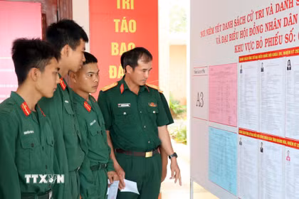 Các chiến sỹ xem kỹ danh sách người ứng cử. (Ảnh: Công Thử/TTXVN)