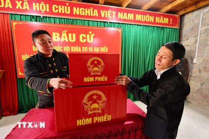 Sắp xếp hòm phiếu, trang trí hội trường, dán danh sách bầu cử tại nhà văn hóa thôn Lô Lô Chải, xã Lũng Cú, tỉnh Tuyên Quang. (Ảnh: Minh Đức/TTXVN)