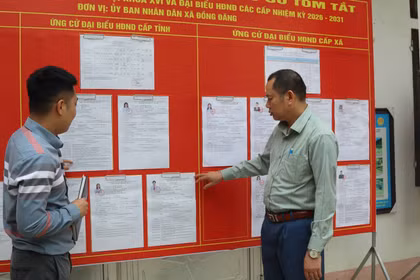 Đảng viên Chi bộ thôn Nam Quan, xã biên giới Đồng Đăng, tỉnh Lạng Sơn tuyên truyền hướng dẫn bầu cử tại nơi niêm yết danh sách những người ứng cử. (Ảnh: Quang Duy/TTXVN)