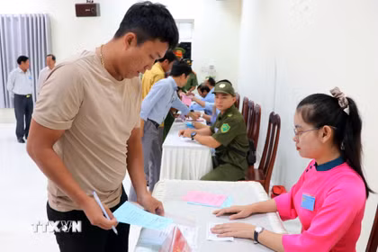 Thành viên Tổ bầu cử số 6 (xã Cà Ná) phát phiếu bầu cho cư tri thực hiện quyền công dân của mình. (Ảnh: Công Thử/TTXVN)