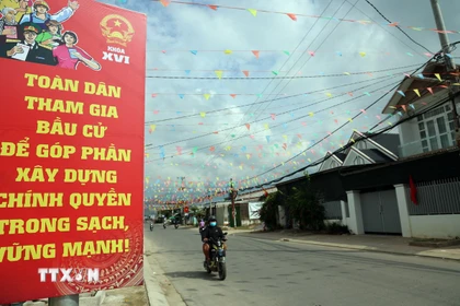 Các tuyến đường về xã Diên Điền, vùng rốn lũ lịch sử 11/2025, được trang hoàng rực rỡ cờ hòa. (Ảnh: Đặng Tuấn/TTXVN)