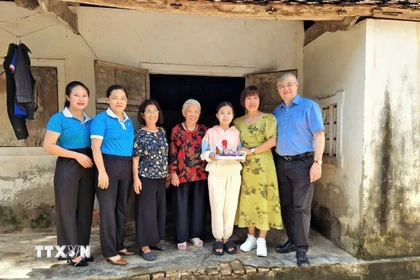 Tiến sỹ Phan Bích Thiện (thứ 2 từ phải sang), Chủ tịch Diễn đàn phụ nữ Việt Nam tại châu Âu, thăm gia đình con đỡ đầu tại Việt Nam. (Ảnh: TTXVN phát)