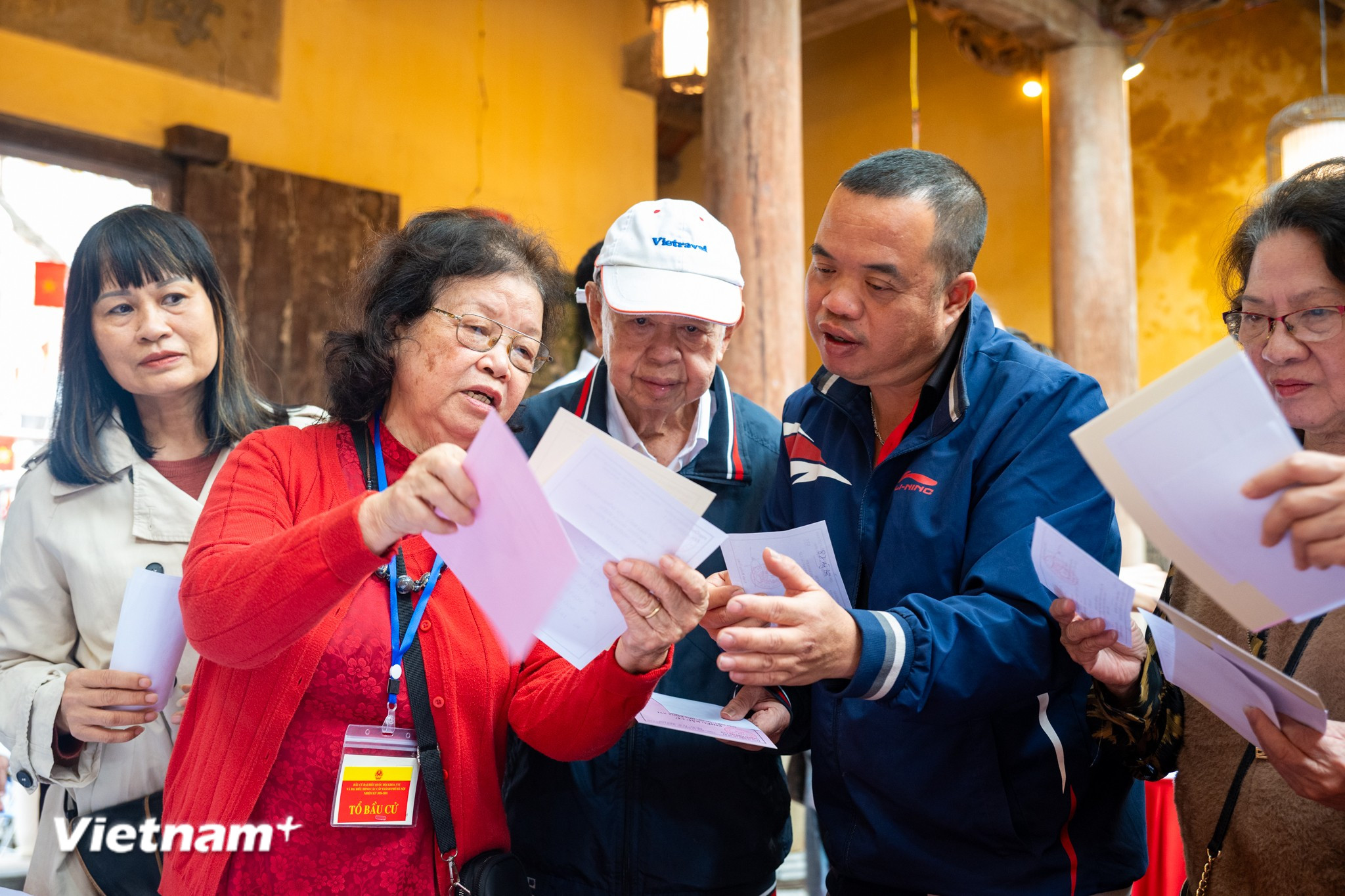 Các cử tri đến bỏ phiếu được thành viên tổ bầu cử hướng dẫn tận tình. (Ảnh: Minh Sơn/Vietnam+)