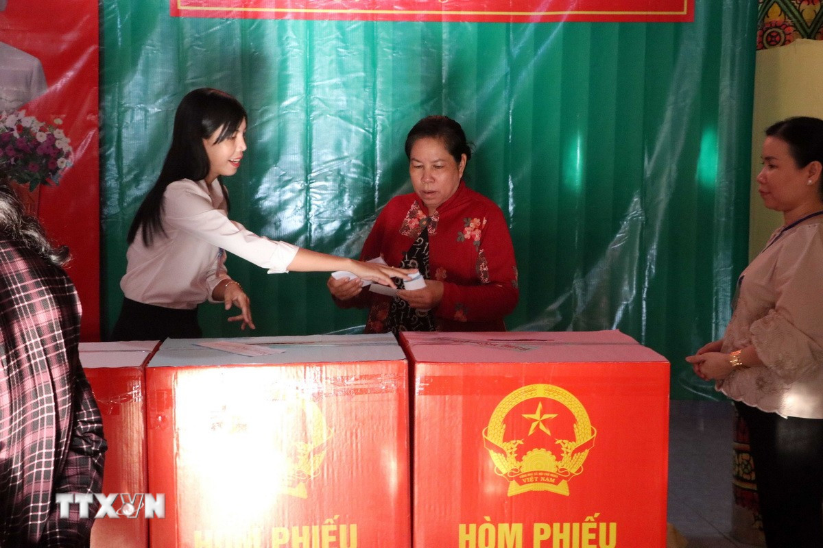 Thành viên tổ bầu cử nhiệt tình hỗ trợ, hướng dẫn cử tri các bước bỏ phiếu đúng quy định. (Ảnh: Trung Kiên/TTXVN)