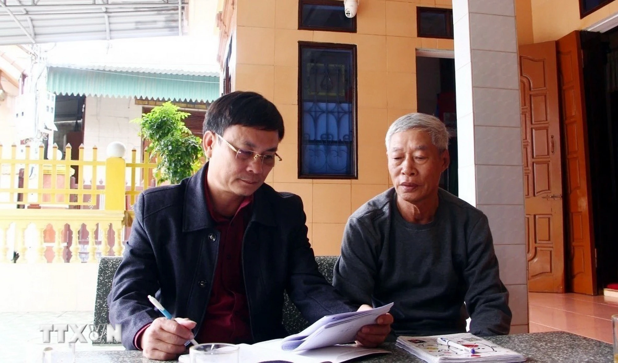 Cán bộ Ban công tác mặt trận khu dân cư Tân Cảnh (xã Hòa Trạch, Quảng Trị) tuyên truyền Luật bầu cử đến các ngư dân địa phương. (Ảnh: TTXVN phát)