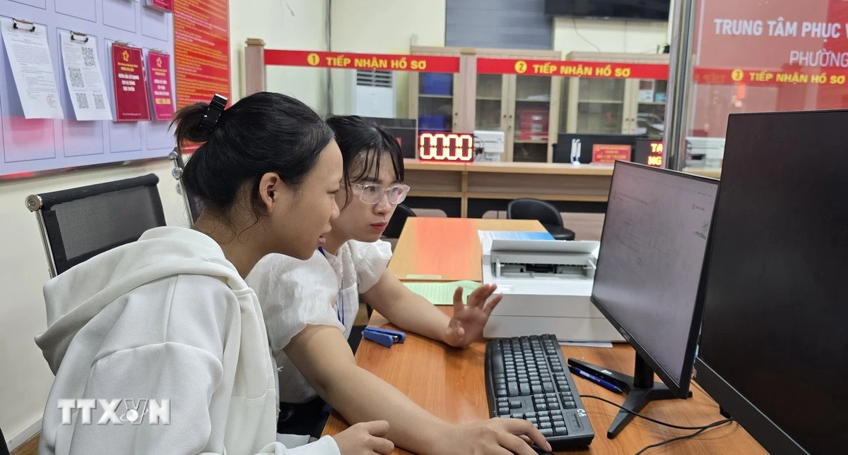 Chị Trần Thị Kim Nhung, chuyên viên phường Phù Liễn, Hải Phòng hướng dẫn công dân gửi hồ sơ đăng ký kết hôn lên Cổng Dịch vụ công Quốc gia. (Ảnh: Minh Thu/TTXVN)