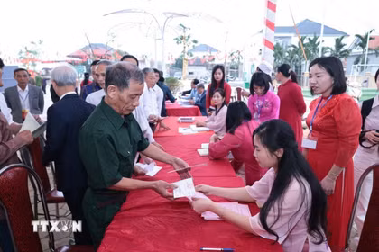 Những cử tri đầu tiên của xã đảo Minh Châu, Hà Nội nhận phiếu bầu cử. (Ảnh: Trần Việt/TTXVN)